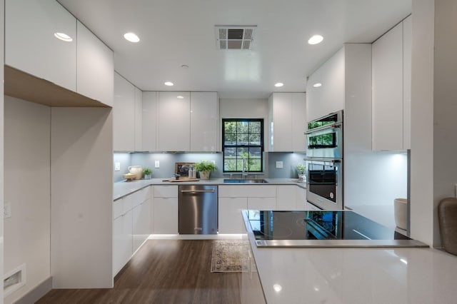 kitchen featuring white cabinets, modern cabinets, visible vents, and appliances with stainless steel finishes