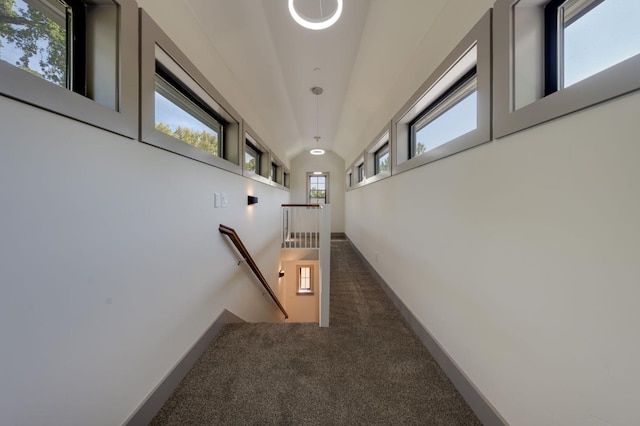 hallway with carpet, baseboards, and an upstairs landing