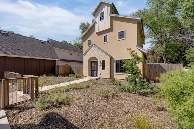 view of front of property featuring stucco siding and fence