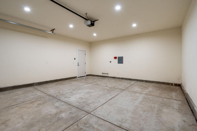 garage featuring recessed lighting, electric panel, baseboards, and a garage door opener