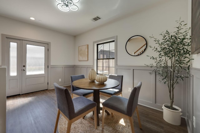 dining space with a decorative wall, wood finished floors, wainscoting, visible vents, and recessed lighting