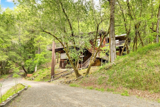 2 Pine Flat Rd, Cazadero, CA 95421 - view of front of property with a wooden deck, driveway, a view of trees, and stairs