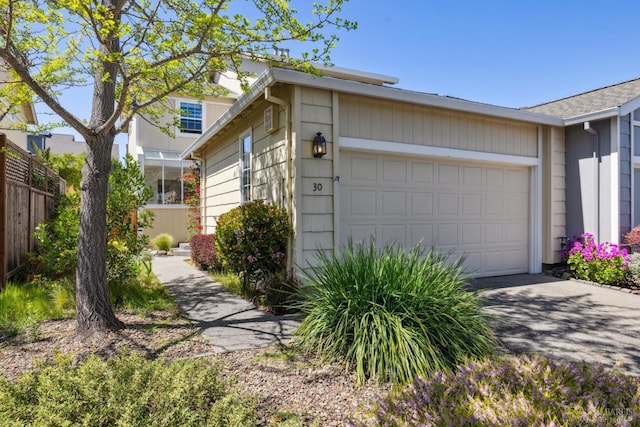 exterior space with an attached garage, fence, and driveway