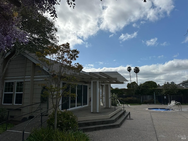 back of property with fence, a patio, and a fenced in pool