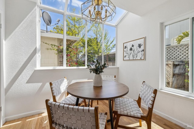 dining space featuring a wealth of natural light, an inviting chandelier, wood finished floors, and baseboards