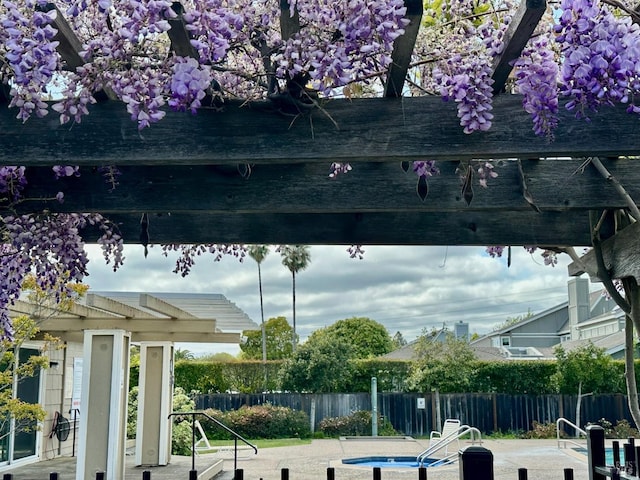 view of property's community featuring fence and a patio area