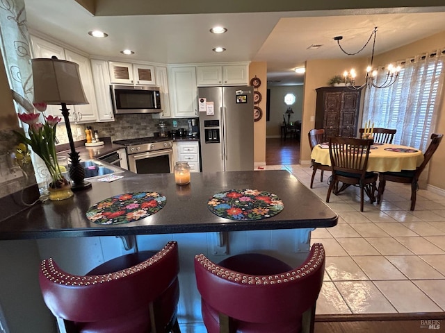 kitchen featuring dark countertops, a chandelier, and appliances with stainless steel finishes
