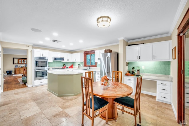 dining room featuring a textured ceiling, visible vents, and ornamental molding