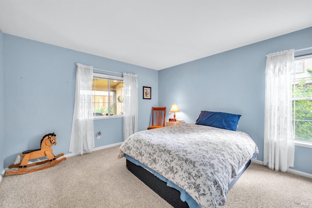bedroom featuring baseboards, carpet flooring, and multiple windows