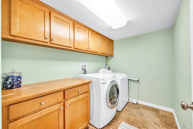 washroom featuring baseboards, separate washer and dryer, cabinet space, and a textured ceiling