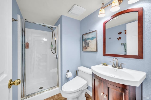 full bathroom featuring toilet, a stall shower, and vanity