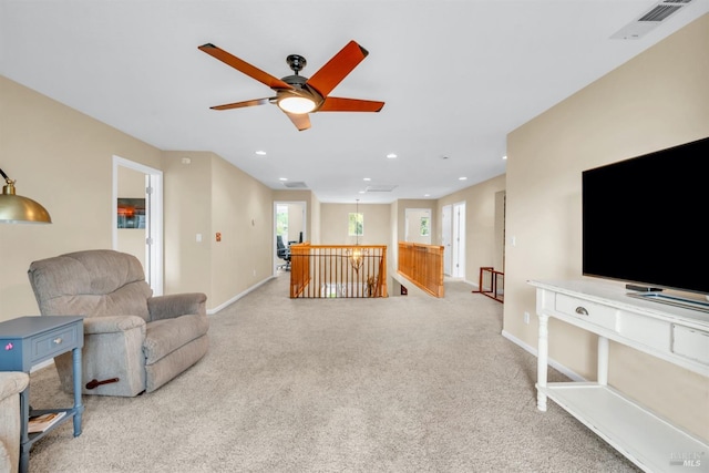 living area with visible vents, ceiling fan, light carpet, and a healthy amount of sunlight