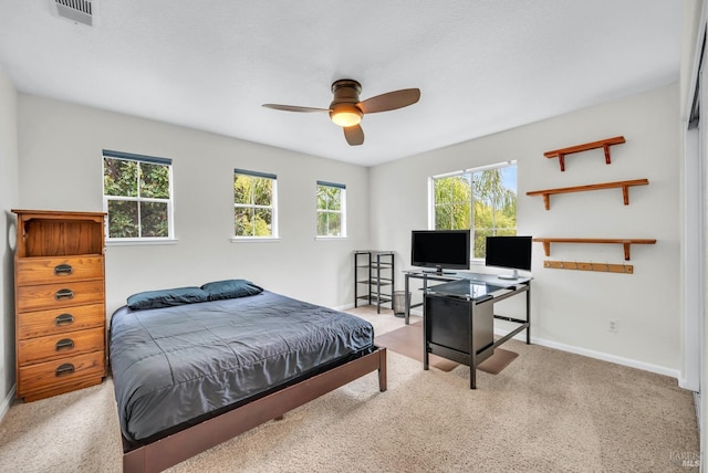 carpeted bedroom with baseboards, visible vents, and a ceiling fan