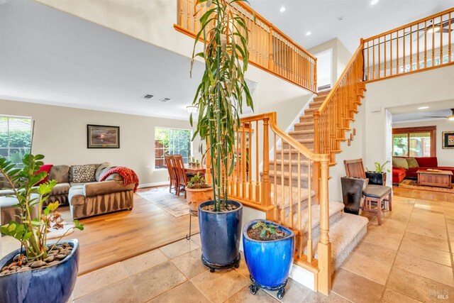 living room with baseboards, recessed lighting, stairs, and a high ceiling