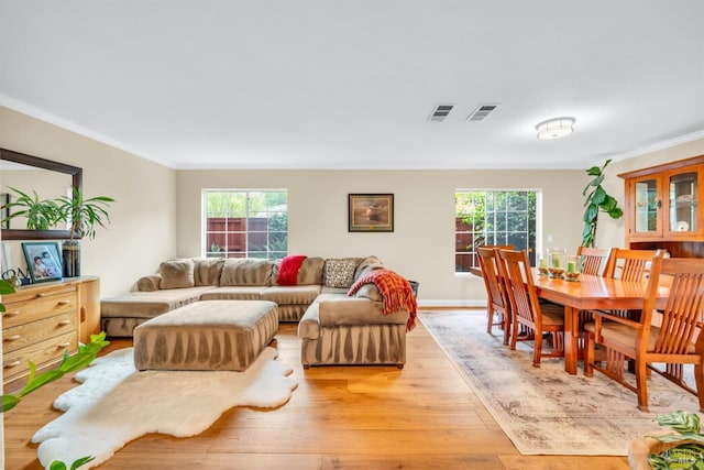 living room featuring ornamental molding, visible vents, and light wood-style floors