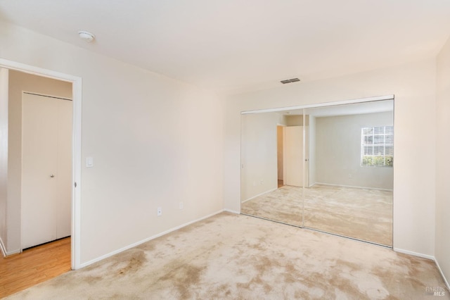 carpeted empty room with visible vents and baseboards