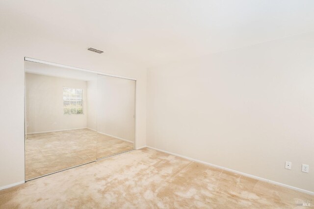 unfurnished room with baseboards, visible vents, and carpet floors