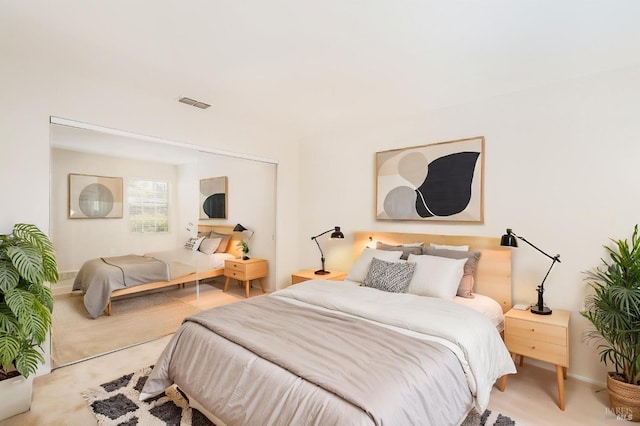 carpeted bedroom featuring a closet, visible vents, and baseboards
