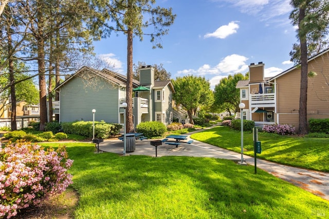 view of home's community featuring a lawn and a patio