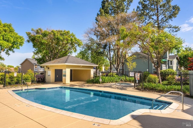 community pool featuring fence, a community hot tub, and a patio