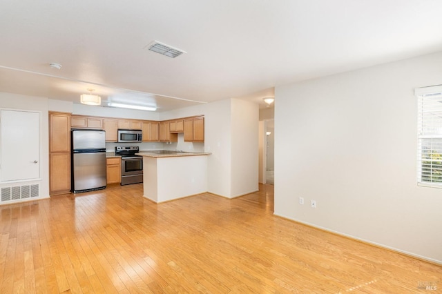 kitchen with appliances with stainless steel finishes, light countertops, visible vents, and light wood-style flooring