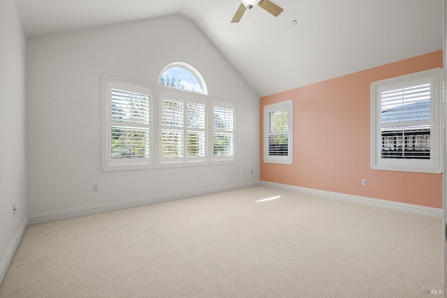 empty room with vaulted ceiling, a ceiling fan, carpet flooring, and baseboards