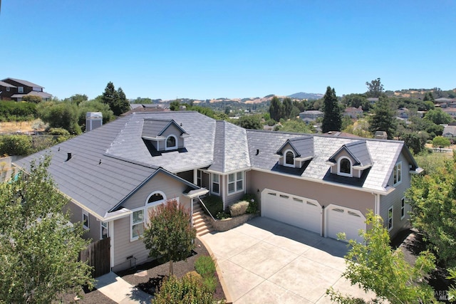 view of front of house featuring an attached garage, driveway, and fence