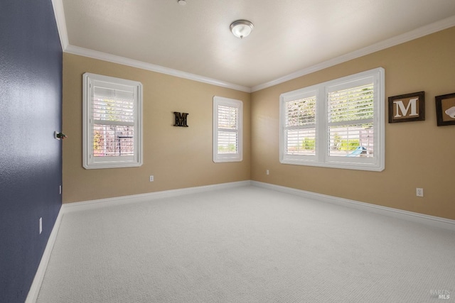 carpeted spare room featuring plenty of natural light, baseboards, and ornamental molding
