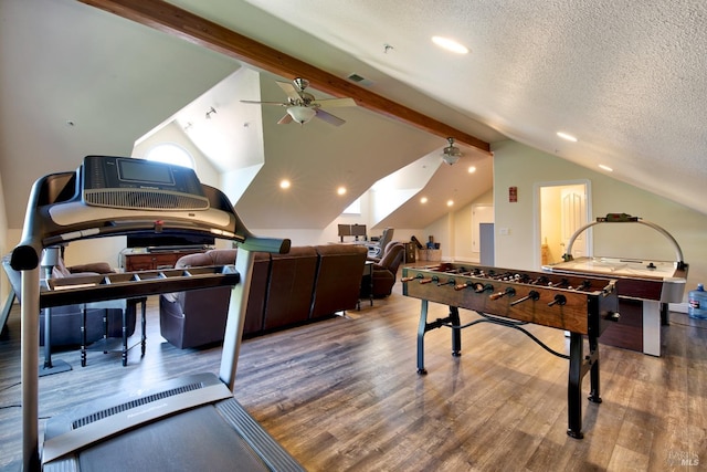 rec room featuring wood finished floors, a textured ceiling, ceiling fan, lofted ceiling, and visible vents