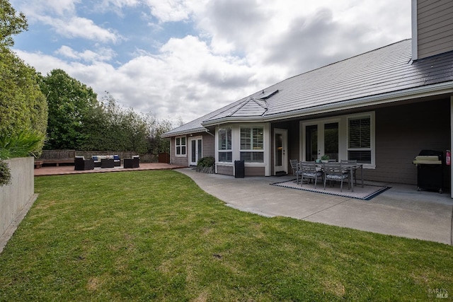 back of house with fence, french doors, a patio, an outdoor living space, and a lawn