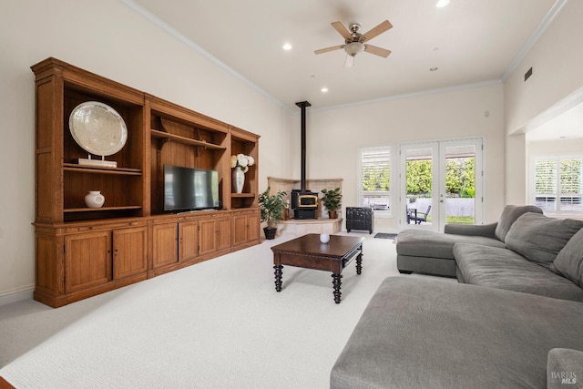 carpeted living area with recessed lighting, a wood stove, crown molding, and a ceiling fan