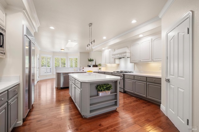 kitchen featuring recessed lighting, dark wood-style floors, gray cabinets, built in appliances, and custom range hood