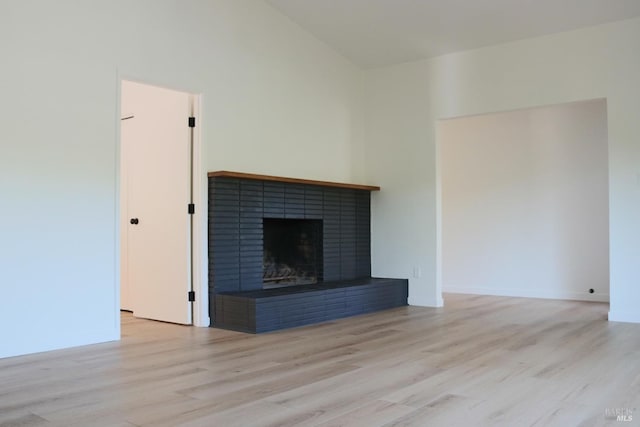 8 Shon Ct, Novato, CA 94947 - unfurnished living room with light wood-style floors, a fireplace, vaulted ceiling, and baseboards