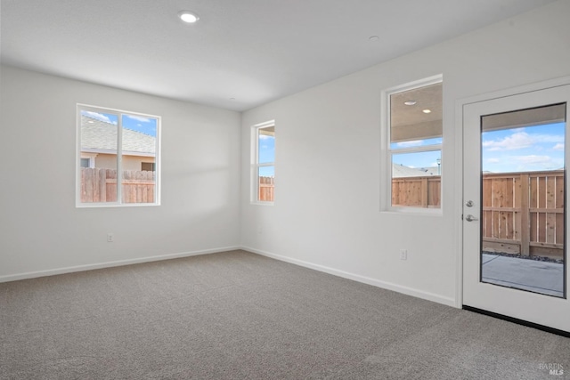 carpeted spare room featuring baseboards and recessed lighting
