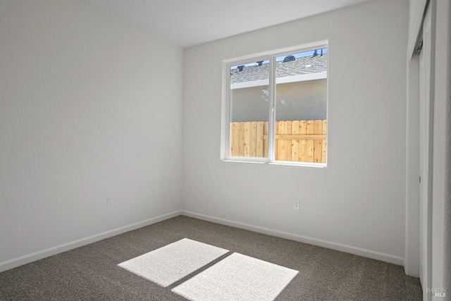 carpeted spare room with baseboards