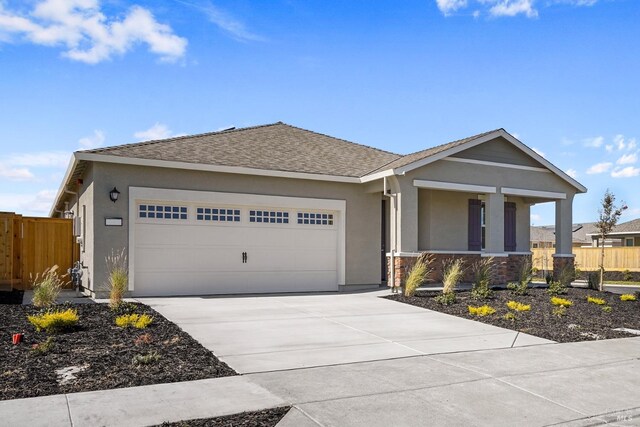 ranch-style home with driveway, an attached garage, stucco siding, and fence