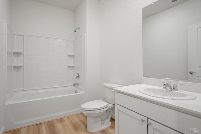 bathroom featuring toilet, vanity, wood finished floors, and tub / shower combination