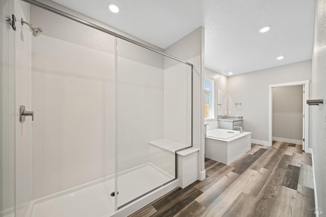 full bath with baseboards, recessed lighting, wood finished floors, and a stall shower