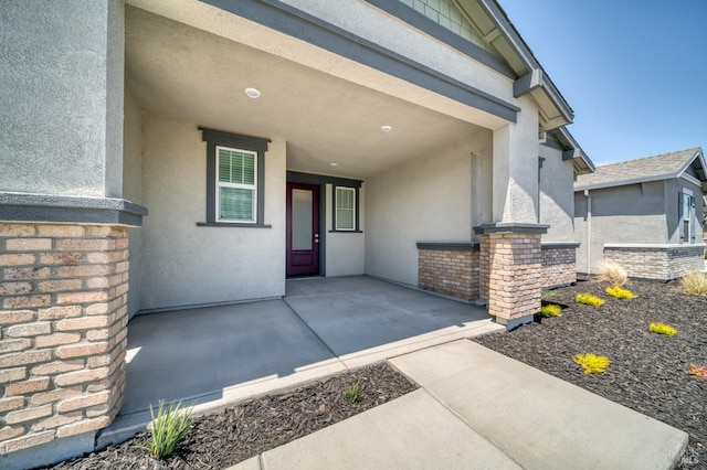 property entrance with a patio and stucco siding