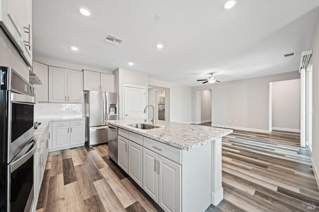 kitchen featuring visible vents, a ceiling fan, stainless steel appliances, and a sink