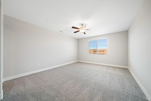 spare room with visible vents, carpet flooring, baseboards, and ceiling fan