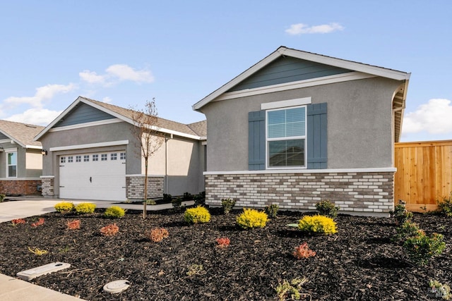 view of front of property featuring stucco siding, fence, driveway, and a garage