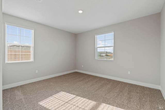 empty room with baseboards and carpet flooring