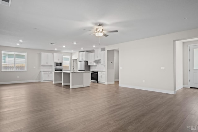 unfurnished living room featuring visible vents, light wood finished floors, ceiling fan, and a healthy amount of sunlight