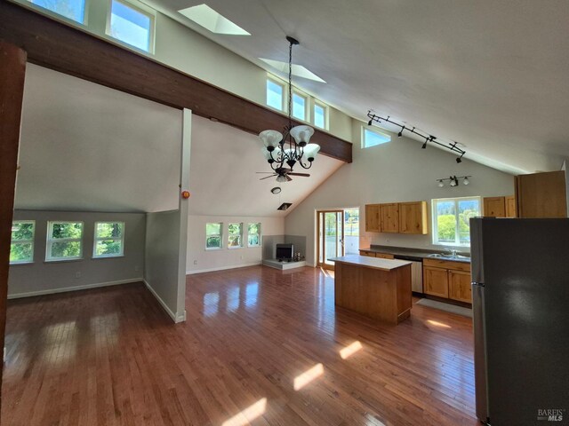 kitchen featuring a center island, open floor plan, a chandelier, a skylight, and appliances with stainless steel finishes