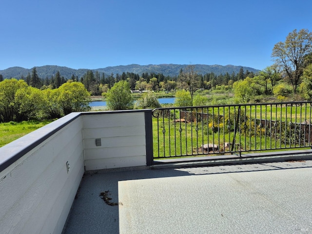 balcony featuring a water and mountain view