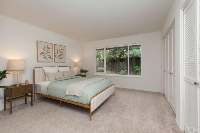bedroom with light colored carpet and baseboards