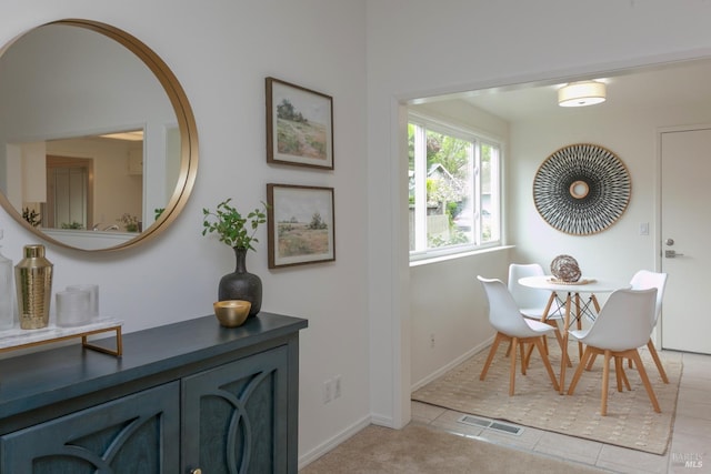 dining space featuring baseboards, visible vents, and light tile patterned floors