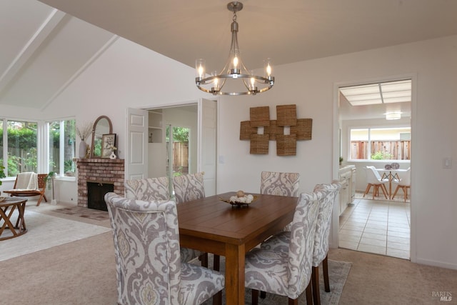 dining room featuring a notable chandelier, light carpet, a fireplace, and vaulted ceiling
