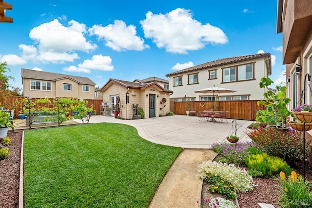 back of house featuring a patio, a residential view, a fenced backyard, a lawn, and a vegetable garden